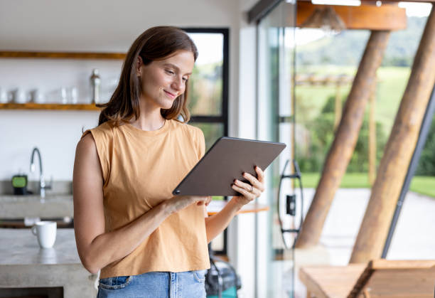 istock Beautiful woman using a tablet computer at home 1383517077