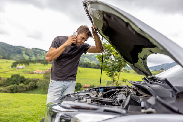 hombre que llama a su seguro de automóvil después de tener una avería en el vehículo en la carretera - stranded fotografías e imágenes de stock