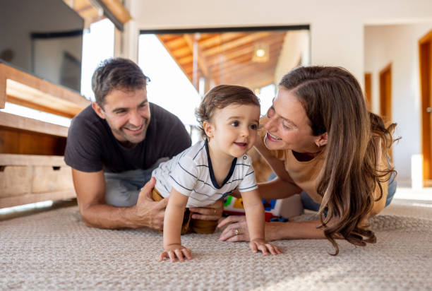 istock Proud parents watching their son crawling at home 1383518868
