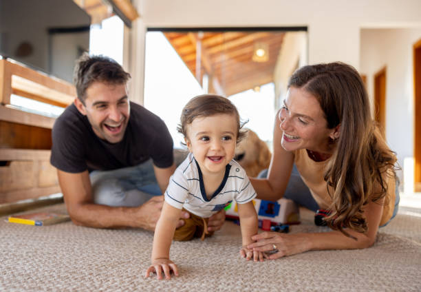istock Happy parents watching their son crawling at home 1383518884