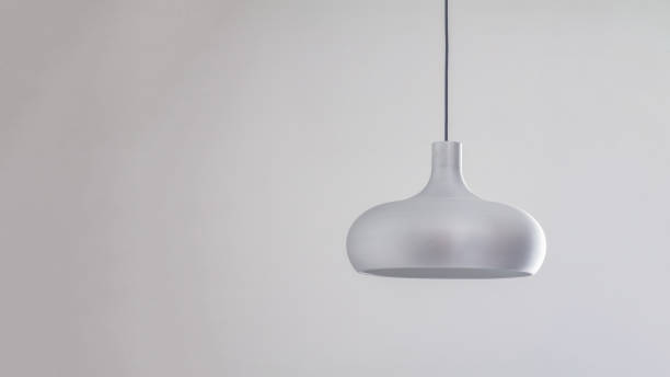 istock A silver metal lamp in a simple semicircular shape hangs on the ceiling against a gray wall background 1383521310