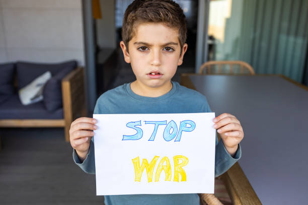 istock Young Boy Holding Stop War Sign 1383527463