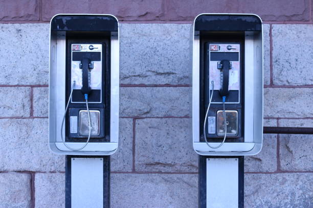 Red wall telephone (taxophone) on gray background close up