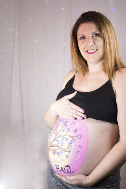 istock Pregnant woman caressing her belly with drawing 1383531732