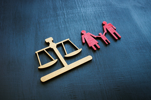 Family law concept. Figures of small scales and families for adoption.