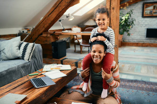 istock Happy black mother having fun while carrying her daughter on shoulders at home. 1383532017