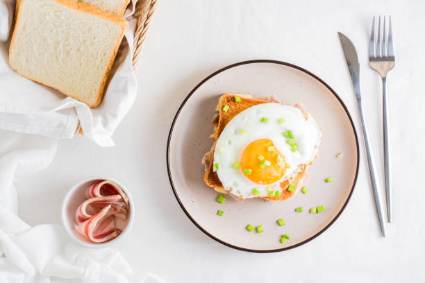 istock Homemade sandwich - croque madame on a plate on a light table. Top view 1383532211