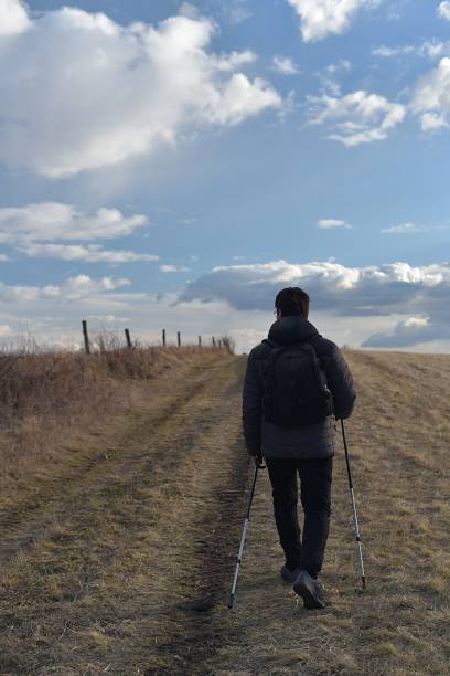istock A man with a backpack walks through the country. Early spring. 1383532489