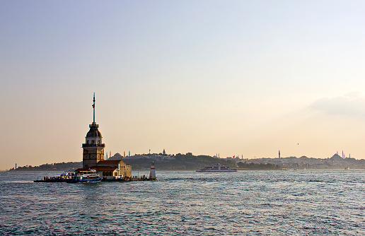 Sunset with Maiden's Tower in Istanbul, It's one of the symbols of Turkey and there is a part of the Bosphorus at the background with people. Some of people visits the restaurant in tower