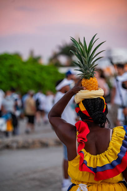 vista trasera de una palenquera que vende fruta en cartagena - trajes tipicos colombianos fotografías e imágenes de stock