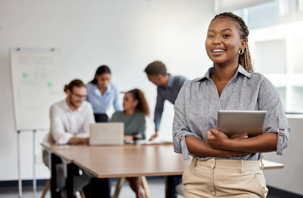 Foto de una mujer de negocios sosteniendo una tableta digital mientras está de pie en la sala de juntas - foto de stock