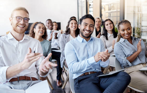 aufnahme einer gruppe von geschäftsleuten, die während einer konferenz in die hände klatschen - audience stock-fotos und bilder