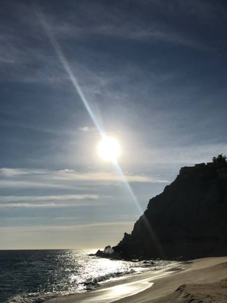 istock Ocean scene with blue sky, cliff and sunbeam 1383533843