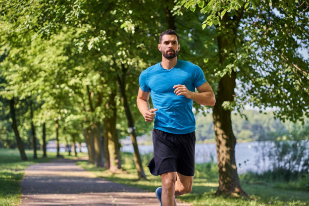 istock Young male athlete practices running in a park 1383534946