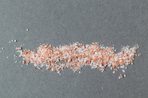 Pink Himalayan salt on a gray background with space for text. Layout.