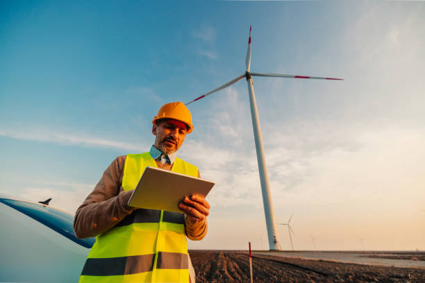 istock Engineer standing in front of turbines on a wind farm 1383538422