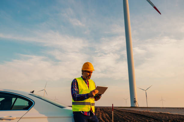istock Man in helmet working with tablet at renewable energy farm 1383538423