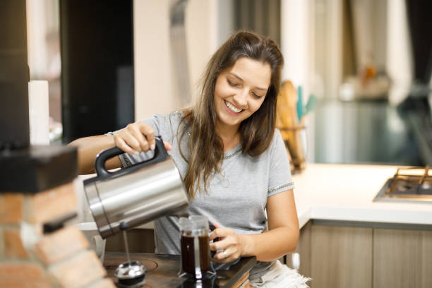 istock Woman happily preparing coffee at home 1383538571