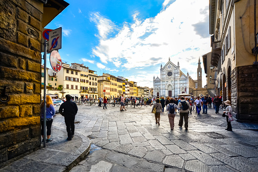 Genoa, Italy - May 18, 2017: Tourists and locals are walking on Piazza Banchi in Historic Center of Genoa, Italy. This photograph was taken midday with full frame camera and Zeiss wide-angle lens.