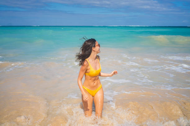 istock Young woman runs from water onto sandy beach 1383541538