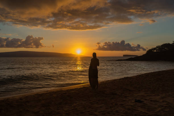 istock Skim boarder relaxes on sandy beach at sunrise 1383542689