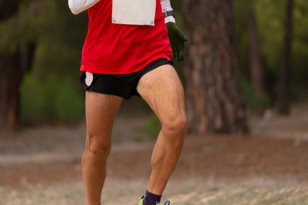 A small group of young adults run an early morning race together.  They are each dressed comfortably in athletic wear and are focused on their breathing.
