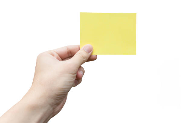 istock Hand holding yellow paper isolated on white 1383552329