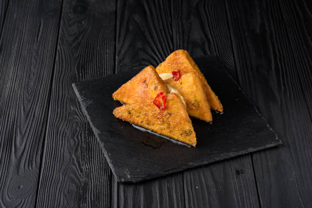 istock Fried tofu with pineapple on a black wooden background. 1383552456