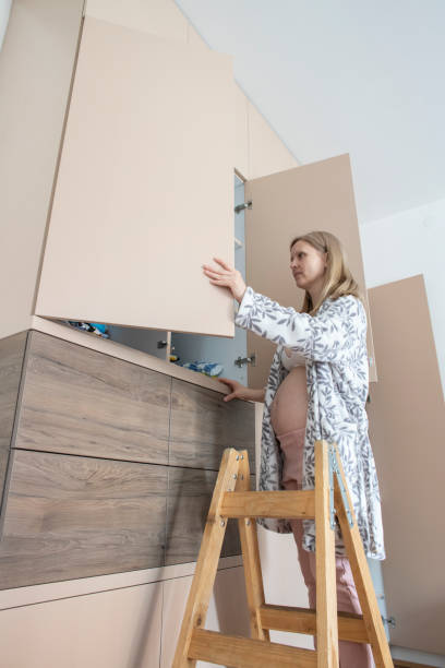 istock Pregnant woman arranging wardrobe 1383556748