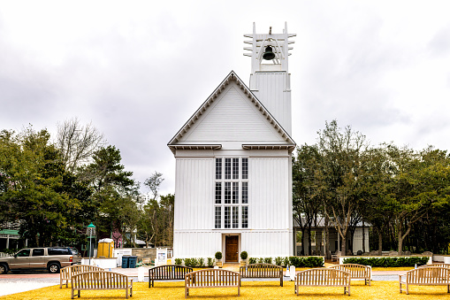 Seaside, USA - January 12, 2021: Seaside, Florida coastal city street with panel of church Chapel wooden white architecture new urbanism style on cloudy winter day