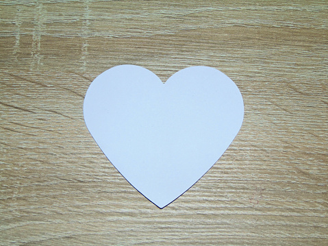 the shape of a white heart on a wooden background