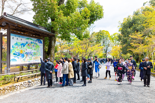 Kyoto, Japan - April 10, 2019: Kinkakuji Golden Pavilion temple Rokuonji zen buddhist shrine with many people tourists looking at map