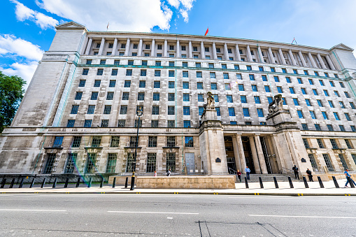 London, UK - June 21, 2018: London Ministry of Defence groverment building exterior facade wide angle view with security guards people on Whitehall street road