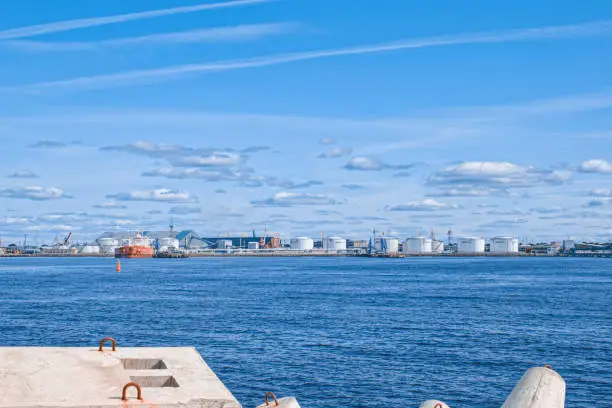 Photo of On a sunny day, the port in Ventspils in the Baltic Sea against the backdrop of breakwaters.