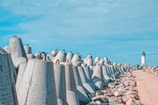Photo of Breakwaters are concrete figured structures. The road to the lighthouse in Ventspils, Latvia.