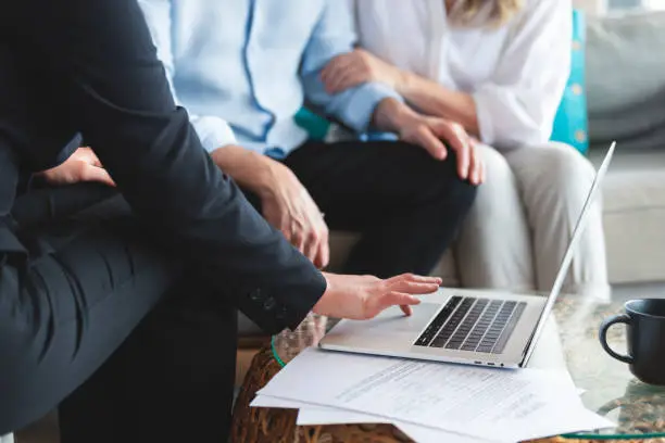 Photo of Mature couple meeting investments and financial advisor at home.