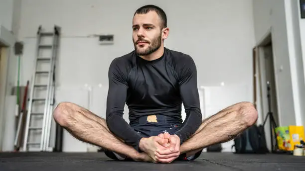 Front view of one man stretching during warm up at brazilian jiu jitsu bjj grappling or luta livre training