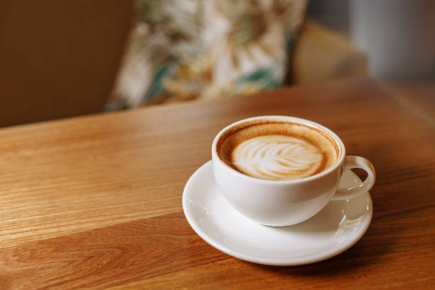 istock A white cup of coffee on a wooden table. 1383576522