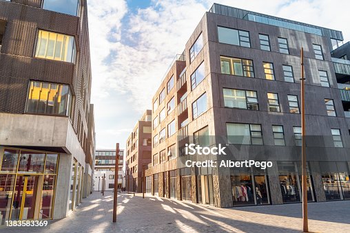 istock Modern architecture and shops along a deserted pedestrianized street at sunset 1383583369