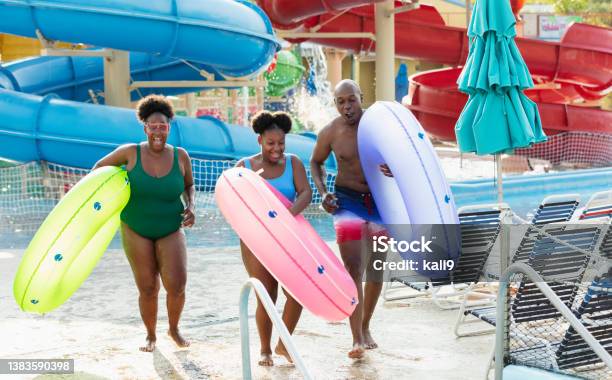 Family At Waterpark Carry Inflatable Rings To Lazy River Stock Photo - Download Image Now