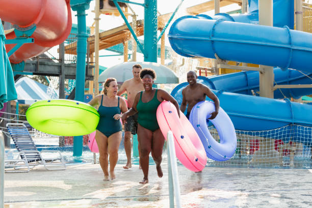 istock Two couples carrying inflatable rings to lazy river 1383591970