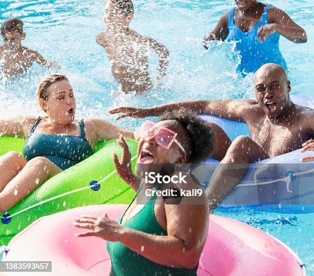 istock Multiracial friends and family splashing on lazy river 1383593457