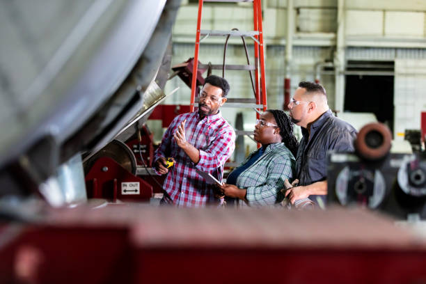 istock Three workers in metal fabrication shop conversing 1383599742