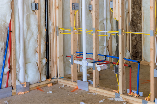 Buildt new home construction featuring hot and cold water PEX plastic plumbing tubes in bathroom unfinished