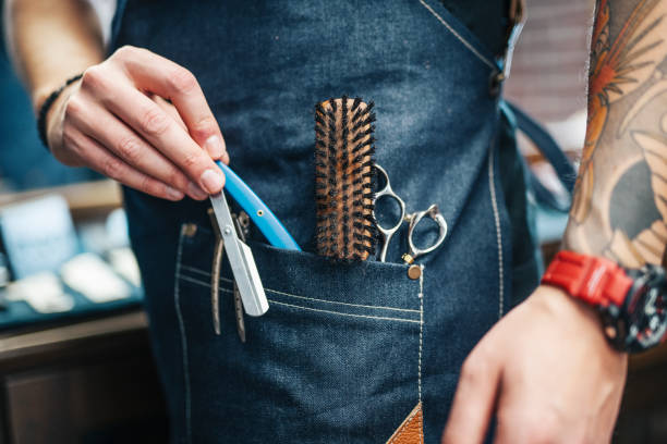 istock Close up of male barber preparing tools for work in his apron. 1383621754