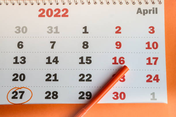 A close-up reminder of the memorable date recorded in the calendar on APRIL 27, a white paper calendar on an orange background with an orange marker A close-up reminder of the memorable date recorded in the calendar on APRIL 27, a white paper calendar on an orange background with an orange marker. number 27 stock pictures, royalty-free photos & images