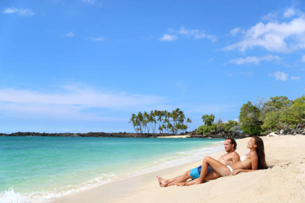 istock Couple sunbathing on beach vacation relaxation 1383622678