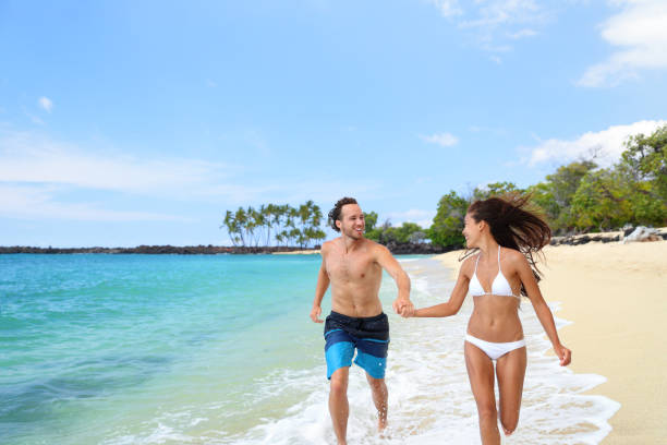 istock Happy couple having fun together running on beach 1383623197