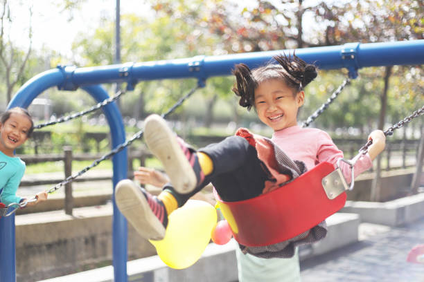istock a father playing swings with his daughters. 1383625137