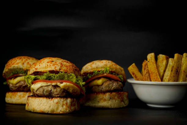 istock Three mini burgers on black background 1383629447